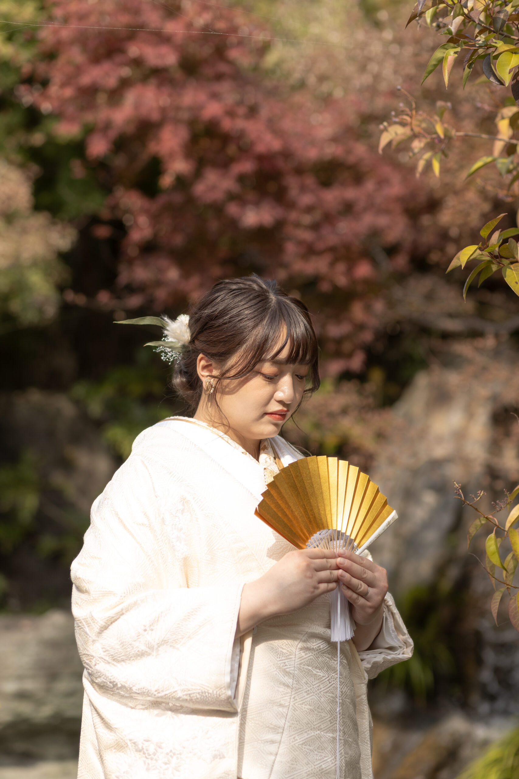 富山の城址公園で紅葉を背景に和装ロケーションフォトウェディングを行う新婦の前撮り写真
