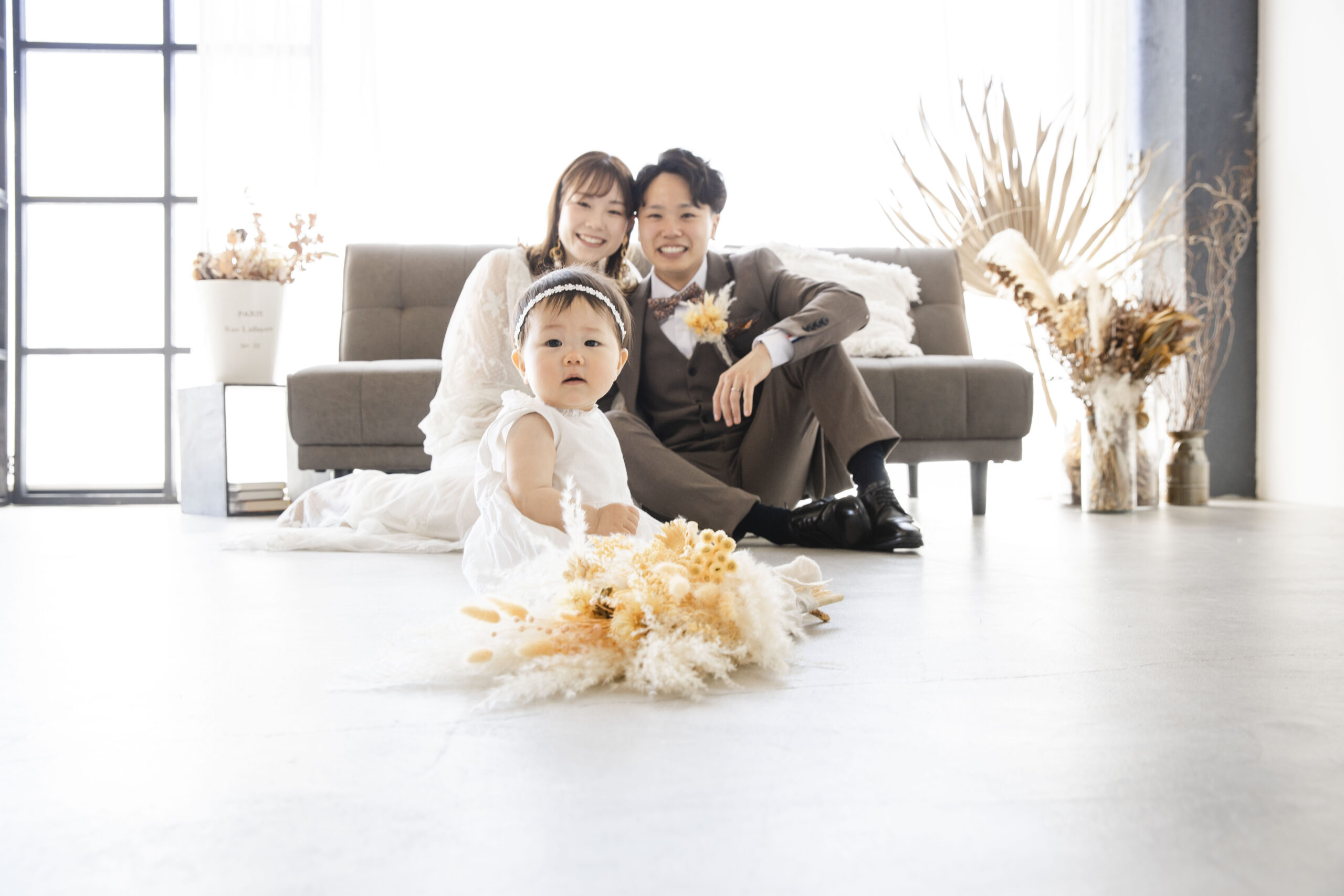 富山県射水市にあるウエディングフォトスタジオシャトンで行った新郎新婦が子供の背中越しに見守っている富山フォトウェディング