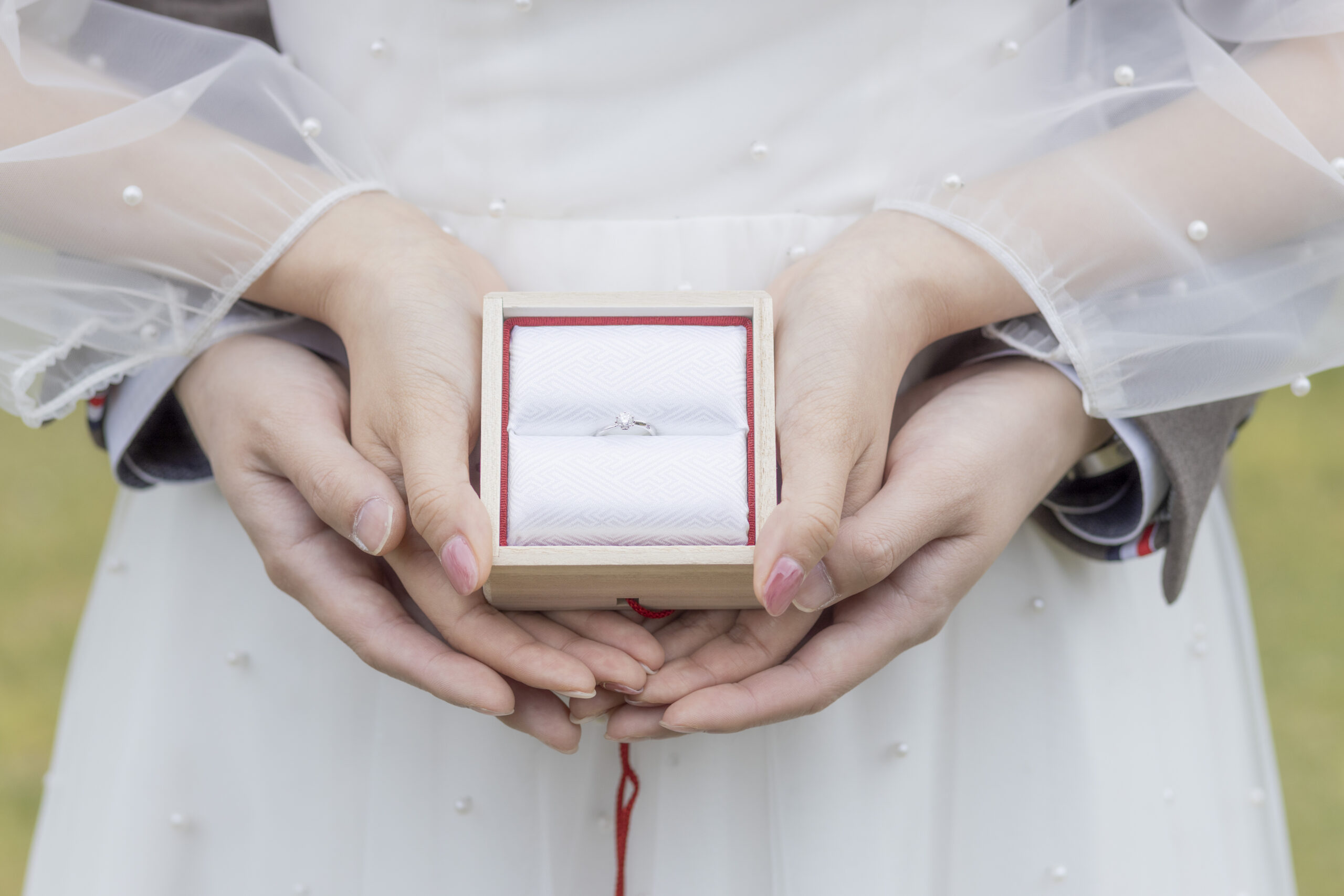 富山県射水市にあるウエディングフォトスタジオシャトンで行った新郎新婦が洋装で指輪と手元のショットを写しているフォトウェディング