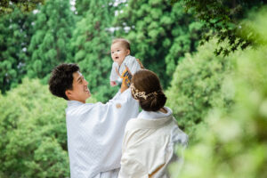 富山県射水市にあるウエディングフォトスタジオシャトンで行った新郎新婦の和装ロケーションフォトウェディングで赤ちゃんと撮影しているフォトウェディング